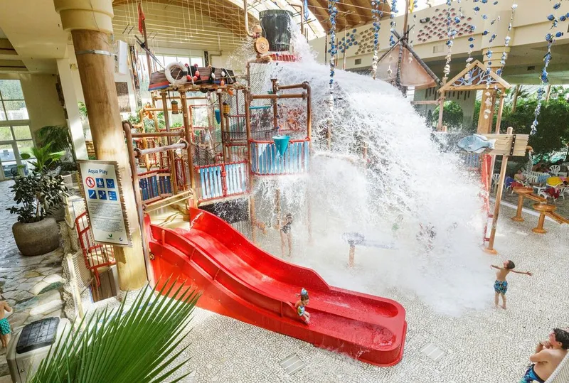 Het Water Playhouse in het Aqua Mundo van Center Parcs Park Hochsauerland, waar een reusachtige emmer met 900 liter water omkiept boven de glijbanen.