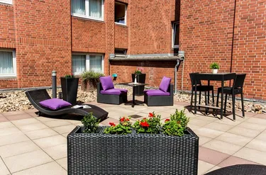 Zonnig buitenterras met comfortabele zitjes bij Mercure Hotel Duisburg City