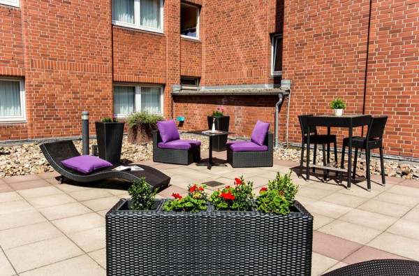 Zonnig buitenterras met comfortabele zitjes bij Mercure Hotel Duisburg City