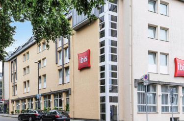 De buitenkant van het Ibis Hotel in Aken met het rode Ibis logo