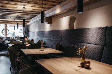 Eetruimte met verschillende tafels en een lange zitbank