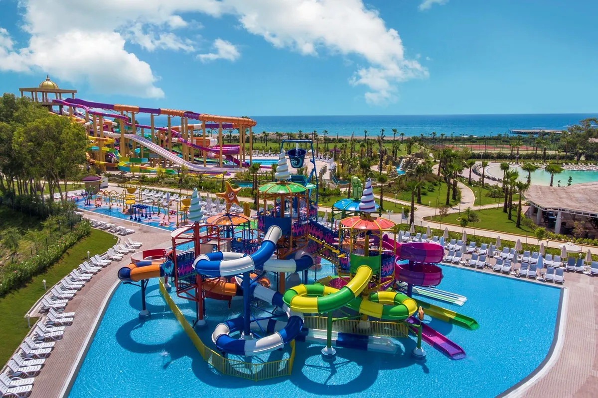 Grote overzichtsfoto vanuit de lucht van het kleurrijke aquapark van Delphin BE GRAND Resort aan zee.