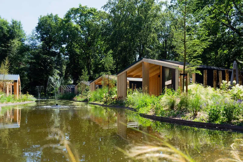 Moderne houten vakantiehuisjes, zogenoemde waterlodges, gelegen aan de rand van een vijver op het park.