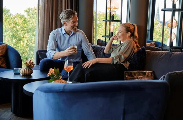 Een stel geniet van een drankje in de sfeervolle bar van ATLANTIC Hotel Münster