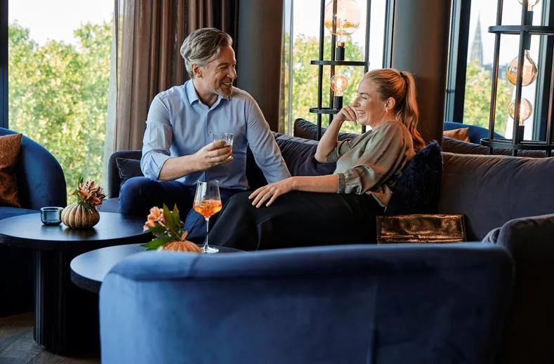 Een stel geniet van een drankje in de sfeervolle bar van ATLANTIC Hotel Münster