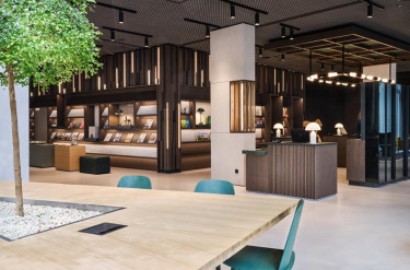 Stijlvolle lobby en bibliotheek in ATLANTIC Hotel Münster met een grote leestafel