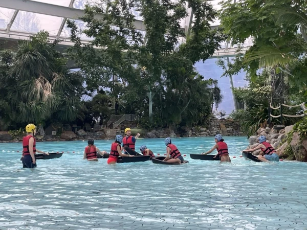 Kinderen staan met zwemvesten aan en helmen op in het subtropisch zwembad van Center Parcs en maken zich klaar voor de wildwaterbaan. 
