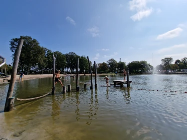 Kinderen spelen op hindernisbaan in zwemvijver van Vakantiepark de Leistert in Limburg
