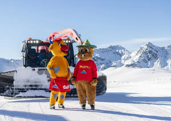 Mascottes staan op de piste in de sneeuw in serfaus Fiss Ladis