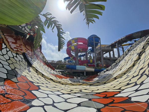 Extreme U-vormige waterglijbaan met kleurrijke torens en spannende afdalingen in waterpark.