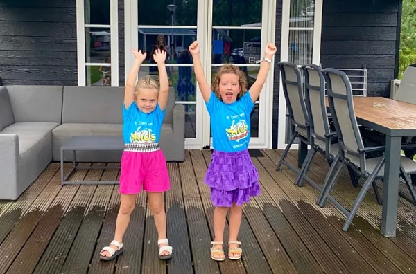 Kinderen juichen terwijl ze voor hun huisje staan bij De Zandstuve