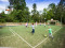 Een groep kinderen speelt een potje voetbal op het multifunctionele sportveld, midden in de bossen van Landal Heideheuvel.