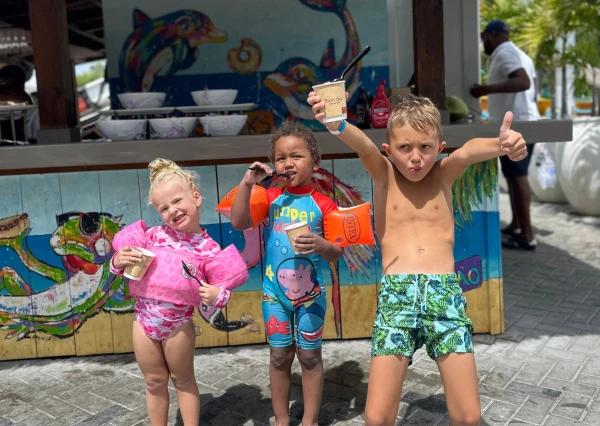 Kinderen lachen vrolijk voor ijskraam met ijsjes