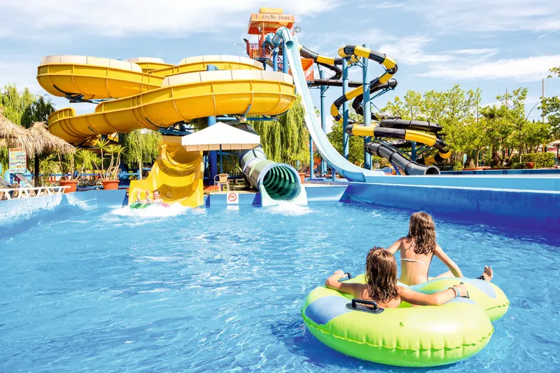 Kinderen drijven op een band in het waterpark van SPLASHWORLD Aqualand Village, meerdere glijbanen voor kinderen 