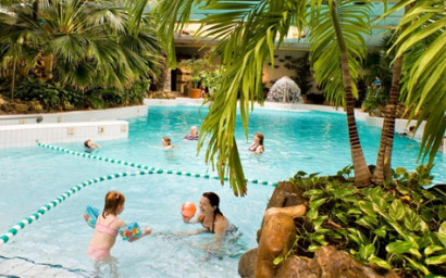 Een moeder en kind spelen vrolijk met een bal in het water van het tropische zwemparadijs Aqua Mundo in Center Parcs Limburgse Peel.