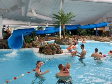 Mensen zwemmen in het subtropisch zwembad van Recreatiepark De Leistert. 