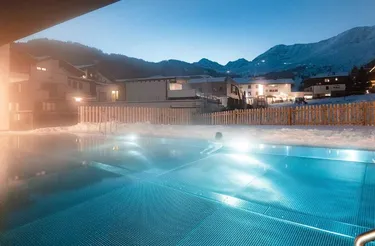 Verwarmd buitenzwembad omheind met hekken in de sneeuw