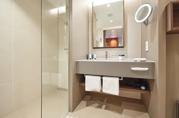 Moderne hotel badkamer in ATLANTIC Hotel Münster met een inloopdouche en wastafel