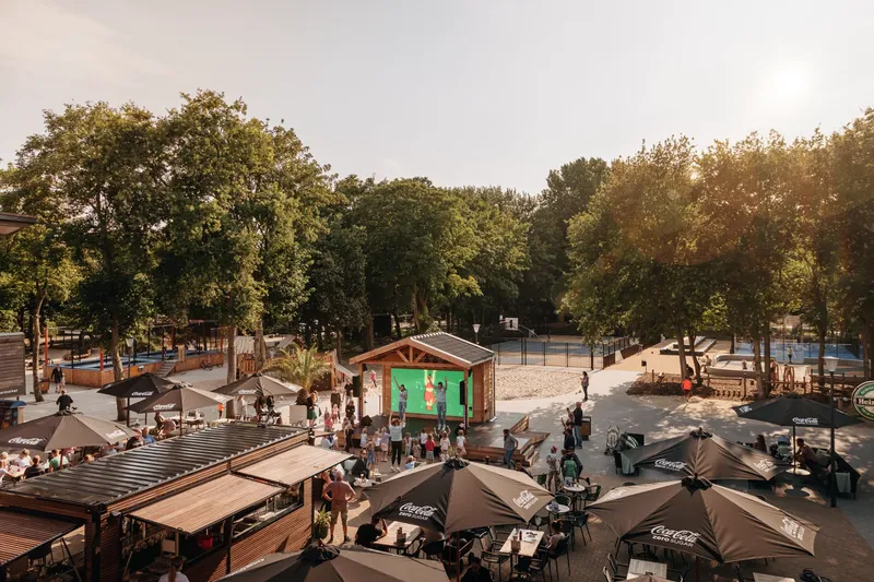 Overzicht van de levendige centrale plaza op Vakantiepark Kijkduin, met zonnige terrassen, horeca en veel gezelligheid in de duinen.