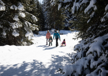 Gezin loopt door skigebied vol sneew in Serfaus-Fiss-Ladis