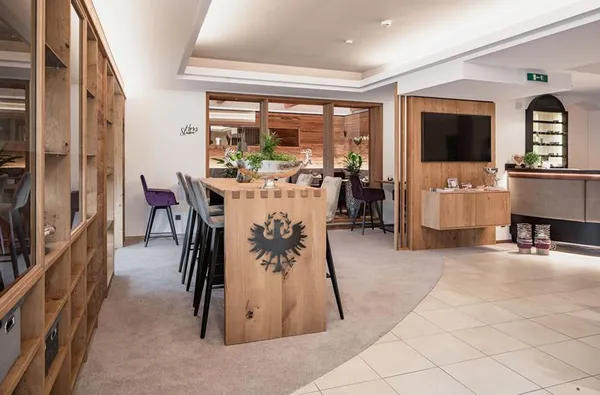 Ruimte met een televisie en een hoge tafel met barkrukken