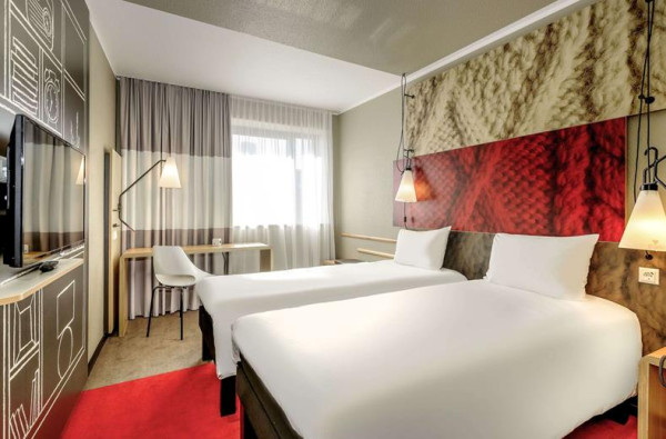 Hotelkamer met twee eenpersoonsbedden en bureau in Ibis Hotel Aken