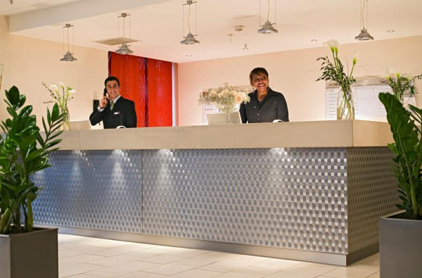 Twee vriendelijke receptionisten achter de balie van Mercure Hotel Duisburg City