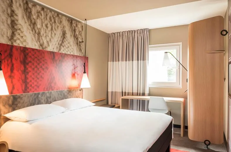 Hotelkamer met een tweepersoonsbed en bureau in Ibis Hotel Aken
