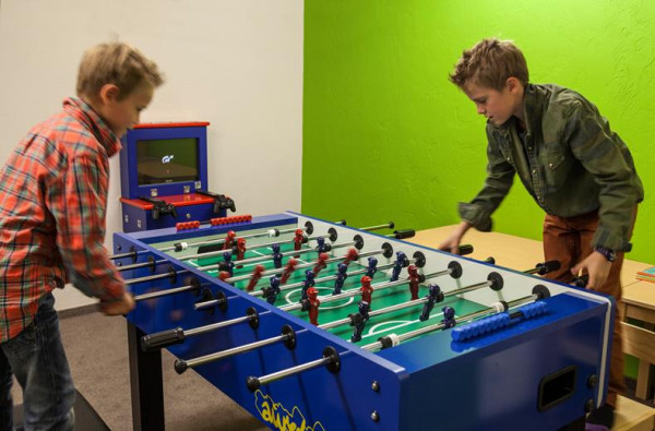 Twee kinderen spelen tafelvoetbal in een kinderspeelruimte