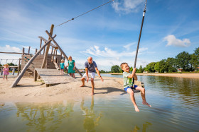 Gezin speelt op het speelstrand van Hof van Saksen