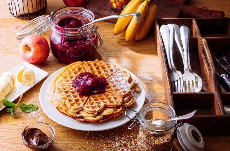 Een heerlijke zelfgemaakte wafel bij het ontbijtbuffet van Ibis Hotel Aken, versierd met jam, fruit en andere toppings, een feest voor kinderen.