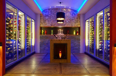 Ruimte vol met wijnkoelers en bar vol dranken in een gekleurd blauw licht