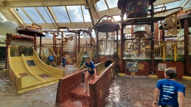 Kinderen spelen en spetteren in een grote waterspeeltuin bij Center Parcs de Huttenheugte.