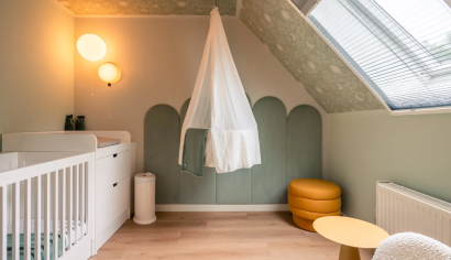 De sfeervol ingerichte babykamer in de Newborn boerderij op Hof van Saksen, voorzien van een ledikant, commode en een hangwiegje.