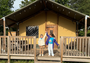 Kinderen staan voor een glamping Safaritent bij Vakantiepark Sallandshoeve