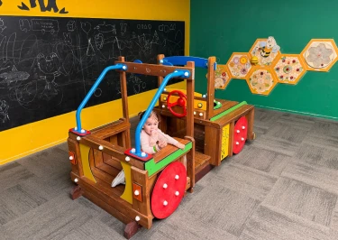 Baby speelt in kinderspeeltoestel in de vorm van een auto