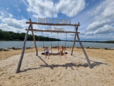 Kinderen schommelen op strand bij Beekse Bergen Lake Resort