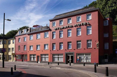 Het vooraanzicht van de rode gevel van Atlanta Hotel in Limburg gelegen aan de straat