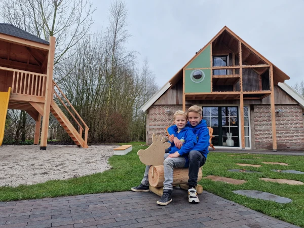 Twee kinderen op wiptoestel voor vakantiehuis op Landal park Orveltermarke