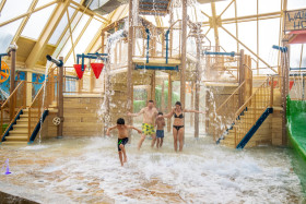 Gezin van vier personen speelt in de spetterende Water PlayHouse in de Aqua Mundo van Center Parcs