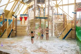 Gezin van vier personen speelt in de spetterende Water PlayHouse in de Aqua Mundo van Center Parcs