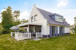 Grote, witte vrijstaande bungalow met een ruim grasveld en overdekt terras op vakantiepark Landal De Vers.