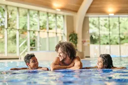Een gezin met kinderen geniet en ontspant in het overdekte binnenzwembad van Vakantiepark De Strabrechtse Vennen.