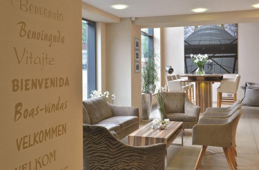 De lobby en zithoek van Parkhotel Oberhausen met welkomstwoorden op de muur