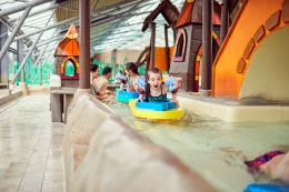 Jonge kinderen spetteren in kleurrijke bootjes in het Canal Play peuterbad