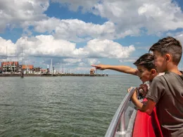 Twee jongens op de boot (Marken Express) van Volendam naar Marken, wijzend naar de haven in de verte.