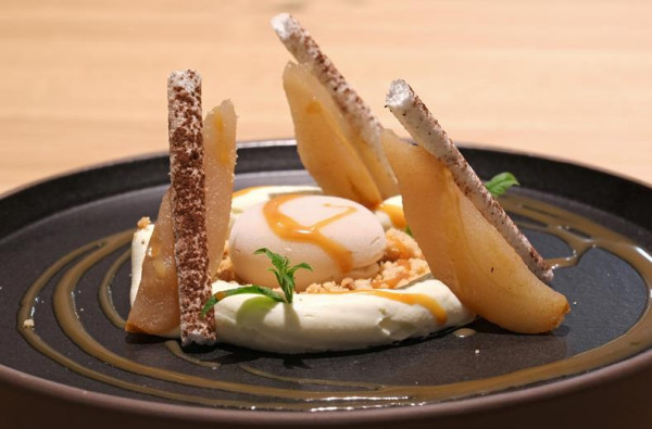 Close-up van een dessert met peer en karamel in het restaurant van ATLANTIC Hotel Münster