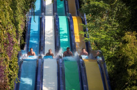 Kinderen en volwassenen racen tegen elkaar op de brede multislide waterglijbaan in het aquapark van Ali Bey Club in Side.