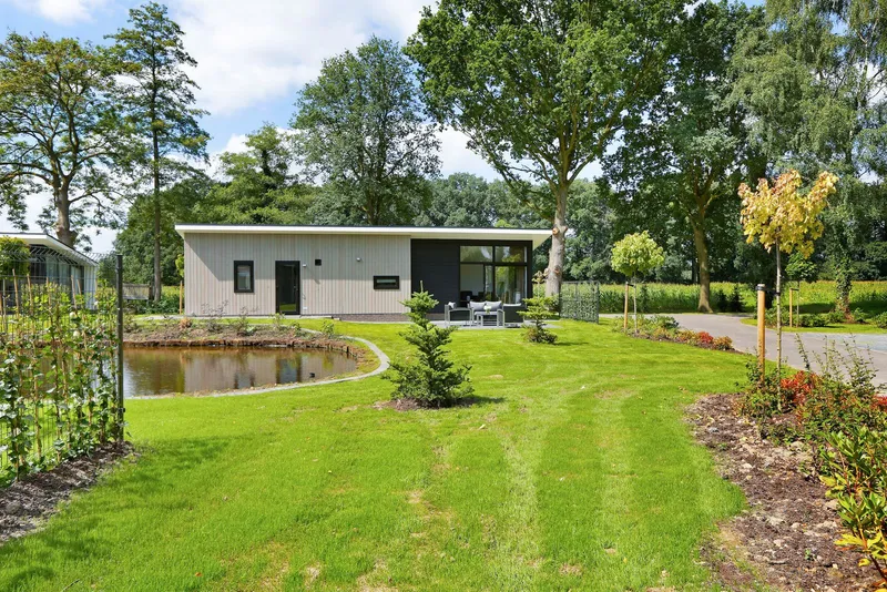 Moderne, vrijstaande vakantielodge op Vakantiepark De Lochemse Berg met een zeer ruime, groene tuin en een eigen vijver.