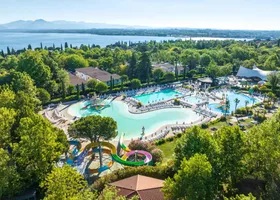 Panorama zwembaden Camping Bella Italia met Gardameer en bergen op achtergrond
